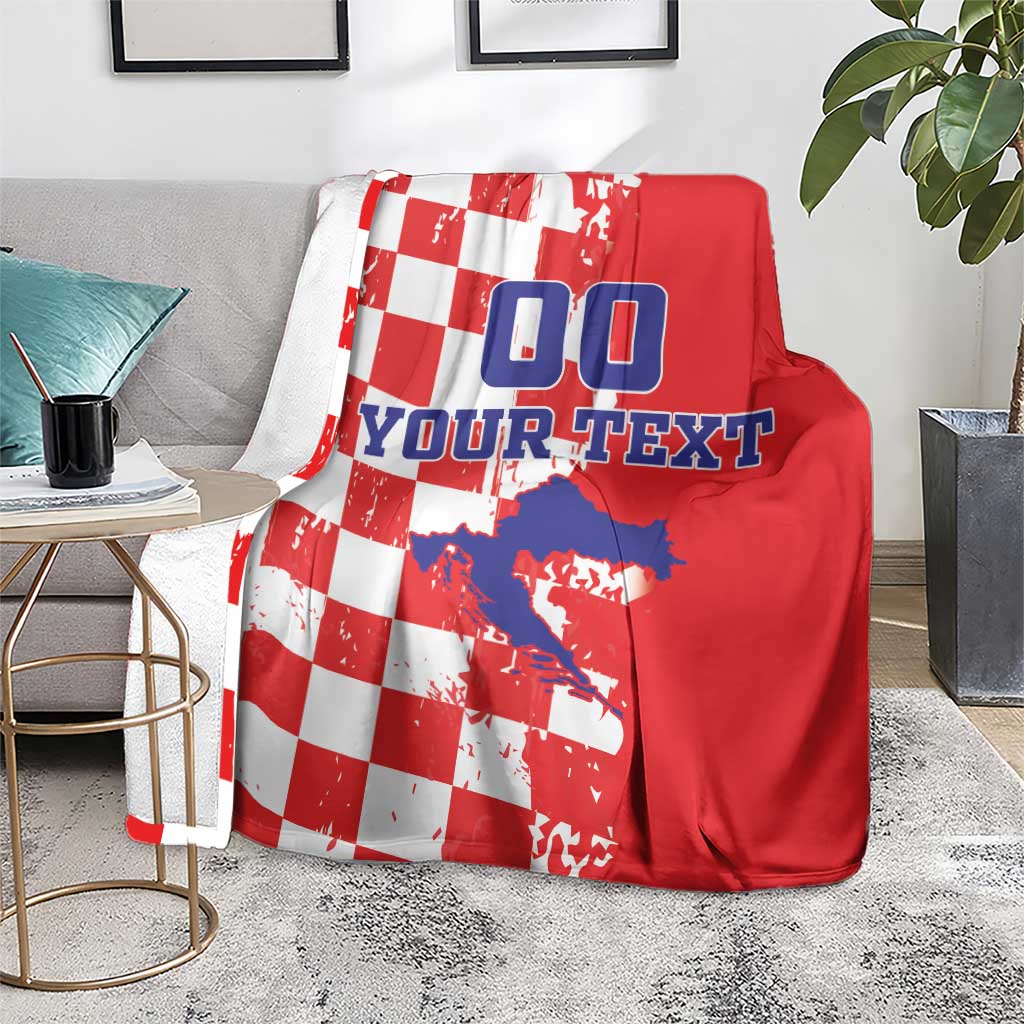 Red and white checkered blanket on a gray couch, showing blue “00” and custom text