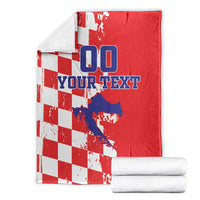 Red and white checkered blanket with blue “00” and custom text, folded with matching rolls