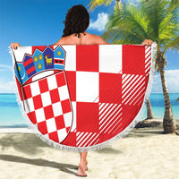 Round red-and-white checkerboard beach blanket with coat of arms, held with fringe border