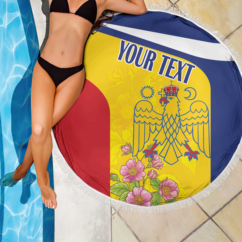 Round beach blanket with white fringe, yellow red blue crest and flowers near pool.