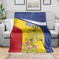Personalized Romania pelican blanket with custom text, yellow blue red, laid on gray sofa