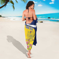 Personalized sarong tied at back, navy/yellow/red with pelican emblem and pink flowers