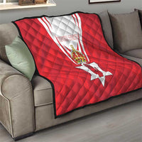 Red quilt blanket with Northern Ireland crest and 'YOUR TEXT' on sofa, quilted diamond pattern
