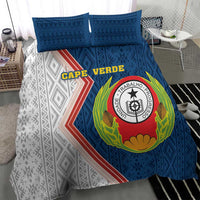 Blue and white duvet with large circular emblem and geometric motifs, 2 blue pillows.