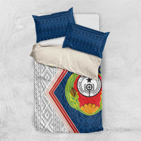 Blue and white bedding set flat lay: emblem duvet with 2 blue pillowcases.