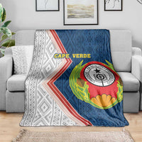 Cape Verde-themed blanket on gray sofa, featuring large crest and chevron border
