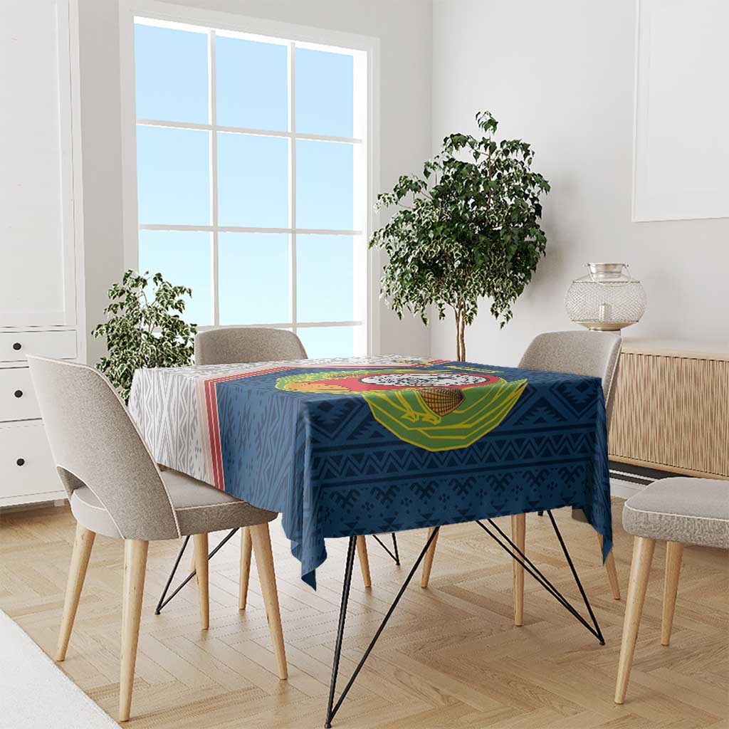 Blue Cape Verde tablecloth with emblem and geometric pattern, dining chairs in view