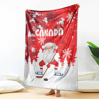 Red Christmas blanket with Santa playing hockey, Canada lettering, and white snowflakes