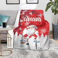 Red Christmas blanket featuring Santa playing hockey, Canada text, and snowflake pattern