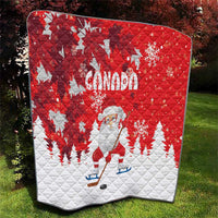 Red and white quilt showing Canada text, Santa in center, snowflakes, and pine trees