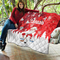 Red and white quilt blanket featuring Canada text, Santa figure, snowflakes, and trees