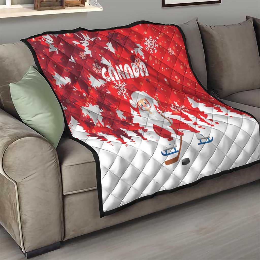 Red and white Santa and Canada quilt draped over a gray sofa with snowflake pattern