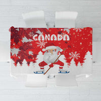 Red Christmas tablecloth with Canada text, Santa playing hockey, and snowflake prints