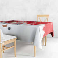 Red and white Santa-themed tablecloth with snowy strip design on the table corner