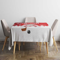 Red and white Christmas tablecloth with Santa hockey motif and scattered snow patterns