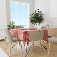 Red Christmas tablecloth draped over dining table, moose and maple leaf design
