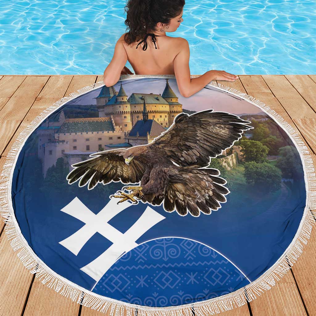 Round beach blanket with dark blue eagle artwork, white X pattern, and fringed border