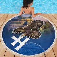 Round beach blanket with dark blue eagle artwork, white X pattern, and fringed border