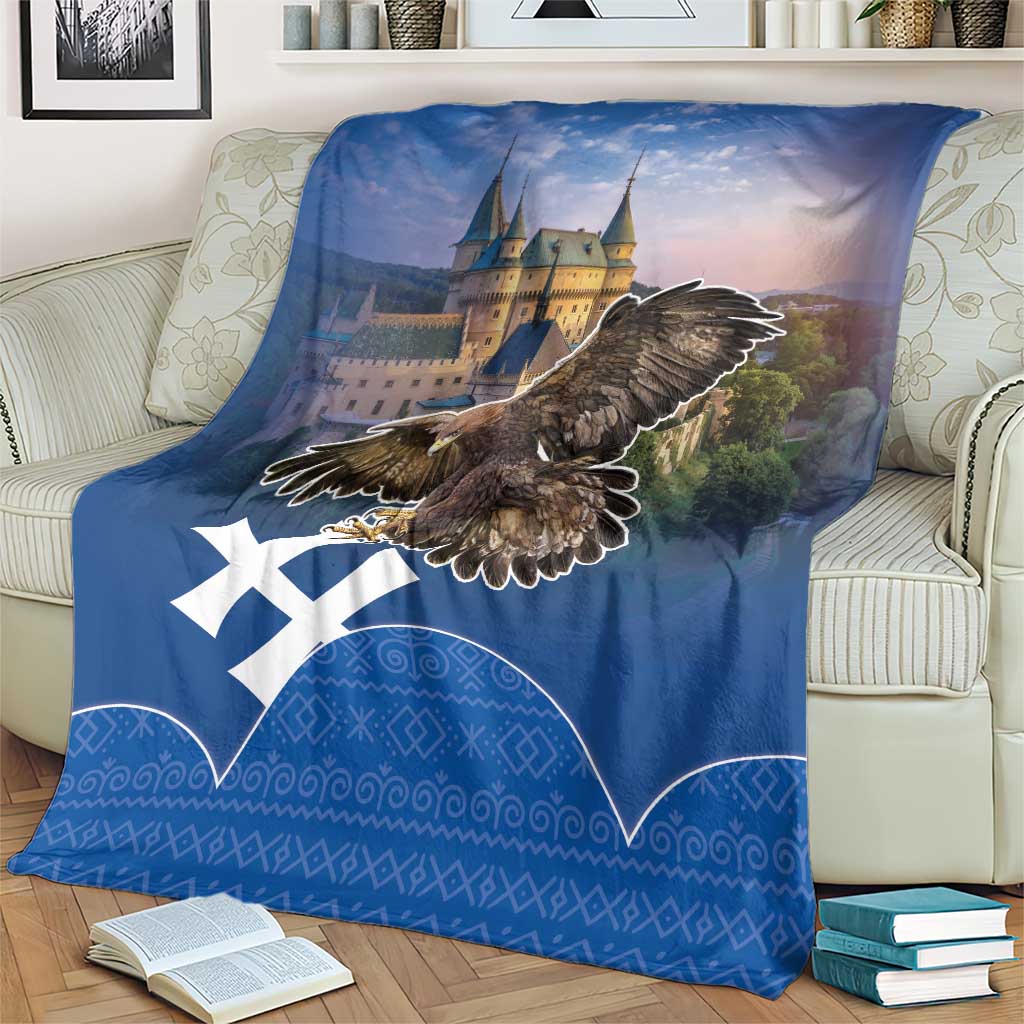 Blue eagle and castle blanket with white cross emblem and decorative Slovak-style border pattern