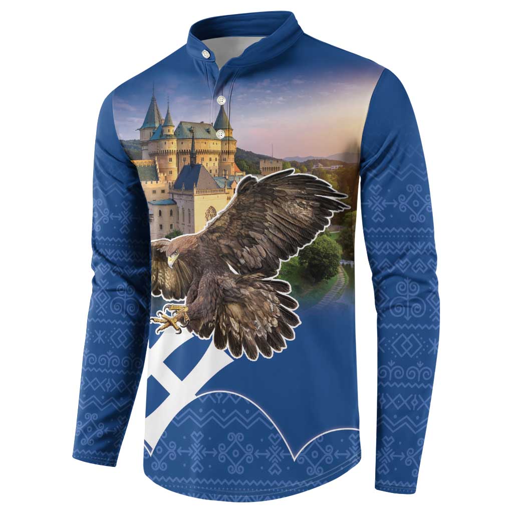 Blue button-up sweatshirt with eagle emblem, castle print, and patterned sleeves