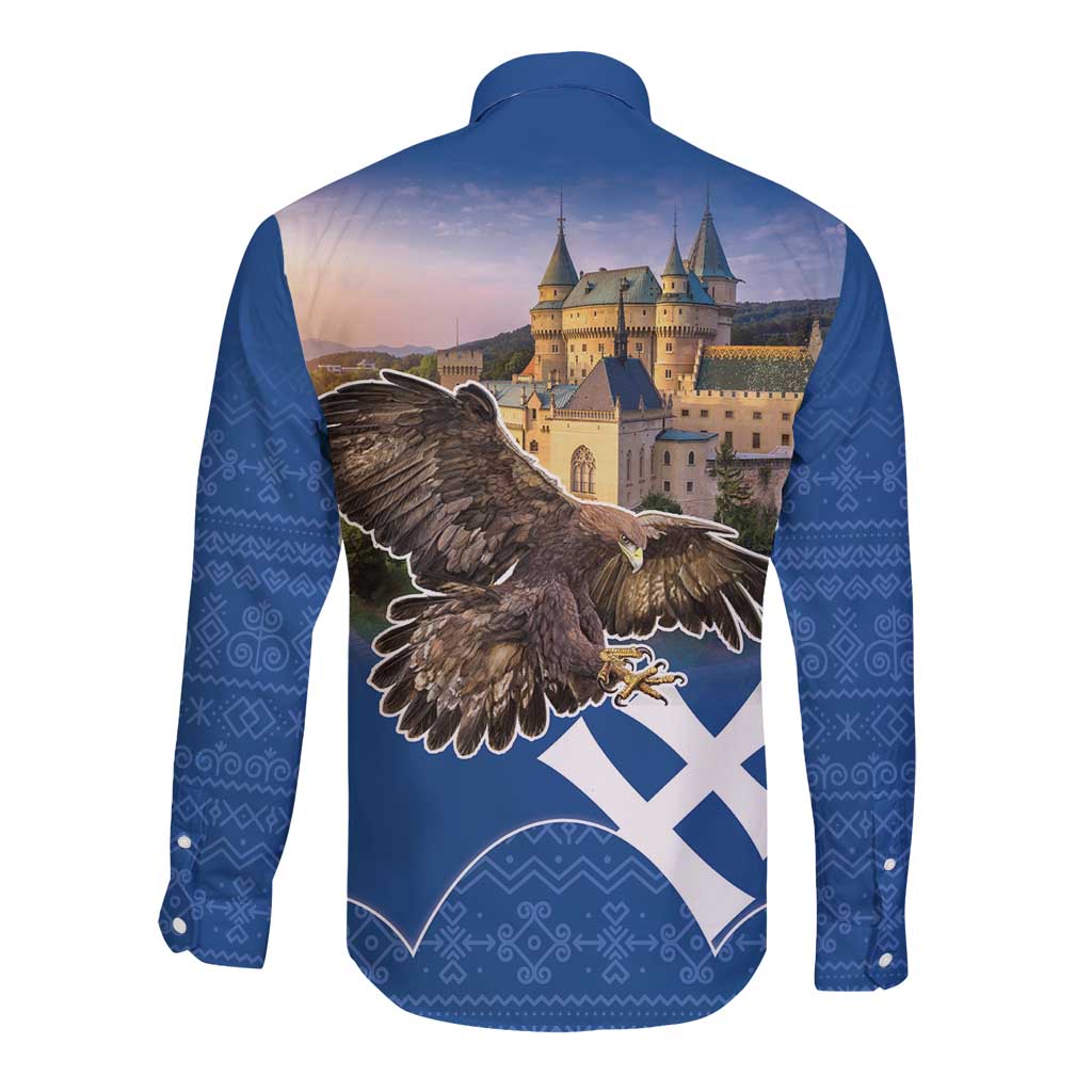 Blue long sleeve button shirt, eagle and castle graphic on back with folk pattern