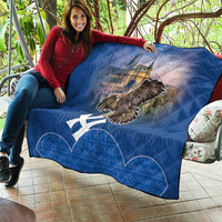 Blue quilt draped over sofa with castle image, flying eagle graphic, and white cross motif