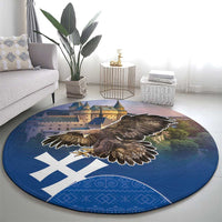 Round blue area rug with brown eagle wings spread, castle skyline, and white cross design