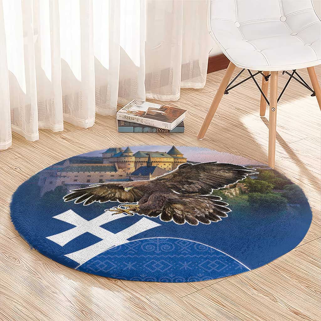 Round blue area rug with brown eagle centered, castle scene, and white geometric cross emblems