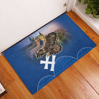 Blue rubber doormat with eagle and cross-style symbol, shown laid on wood floor