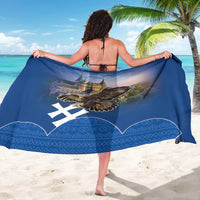 Blue sarong worn as wrap, showing large eagle and castle artwork with patterned border.