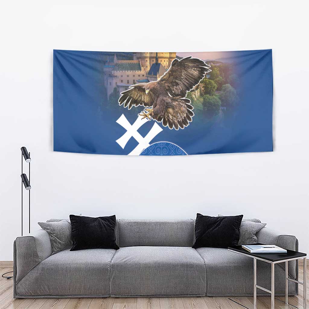 Blue wall tapestry with eagle and castle scene, white cross motif, and blue geometric border