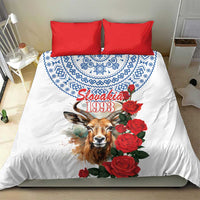 White duvet and red pillowcases with blue motif, chamois graphic, and red rose bouquet design