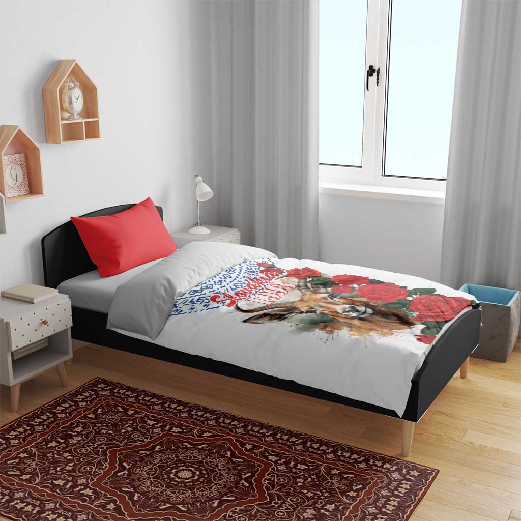White duvet cover with blue motif, chamois illustration, and red rose design with matching red pillow