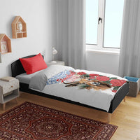 White duvet cover with blue motif, chamois illustration, and red rose design with matching red pillow