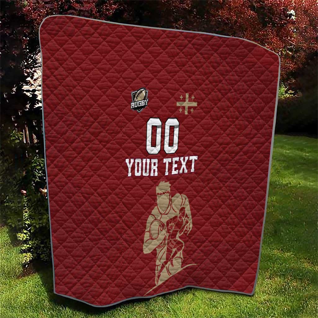 Red quilt with diamond stitching and rugby graphics, '00' and 'YOUR TEXT' on a backyard lawn