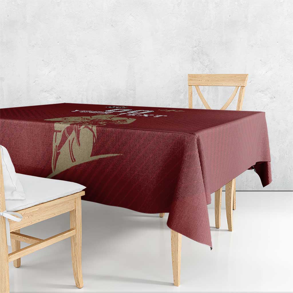 Red rugby tablecloth with gold emblem artwork draped over a bench table