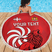 Red round beach blanket with fringe, lion graphic and “YOUR TEXT” print, person seated