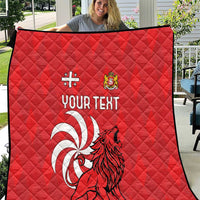 Red quilt with diamond stitching, lion crest art, and “YOUR TEXT” centered