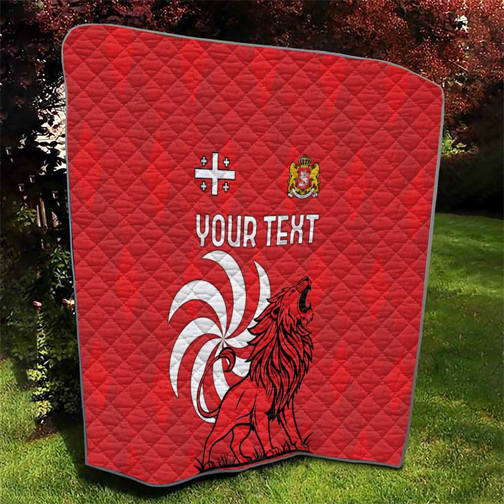 Red quilt with diamond stitching and lion crest graphic, with “YOUR TEXT” in white