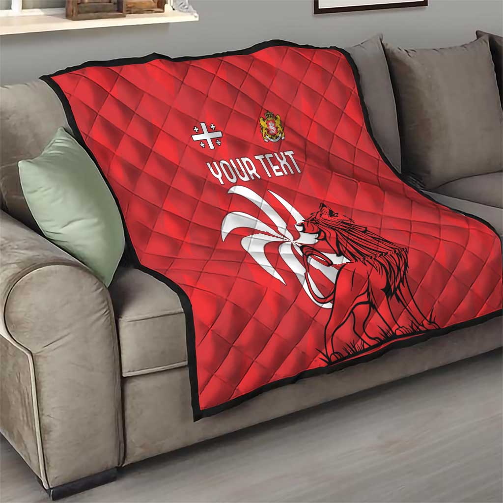 Red quilt with quilted diamonds, lion graphic, and “YOUR TEXT” on a sofa