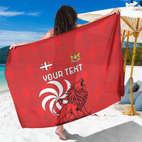 Red personalized sarong with 'YOUR TEXT' and lion graphic, held over beachwear.