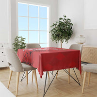 Red tablecloth with lion illustration draped over dining table