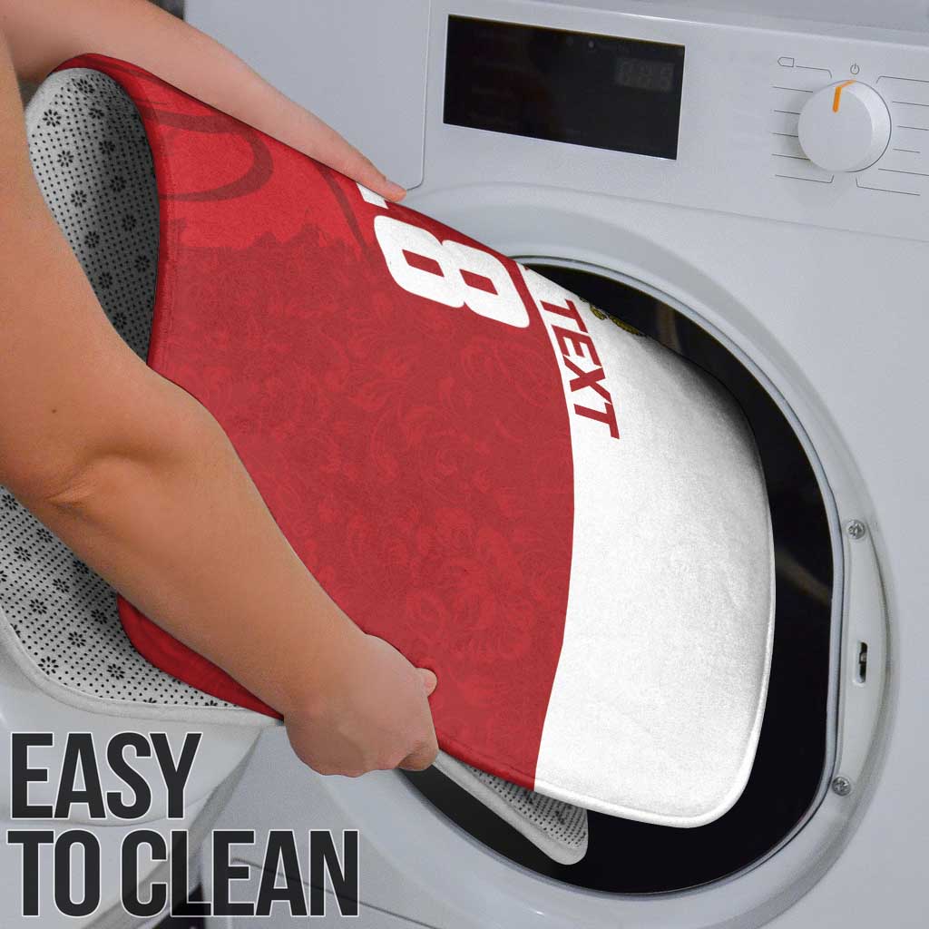 Red basketball-themed bath mat placed into a washing machine for cleaning