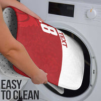 Red basketball-themed bath mat placed into a washing machine for cleaning