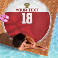 Red round beach blanket with white fringe, crest, custom text and number 18 shown at angle