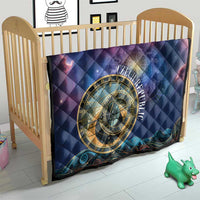 Purple and blue astronomical clock quilt on a crib with gold circular emblem and star pattern