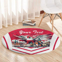 Red round carpet rug with eagle town graphic and 'Your Text' on light wood floor