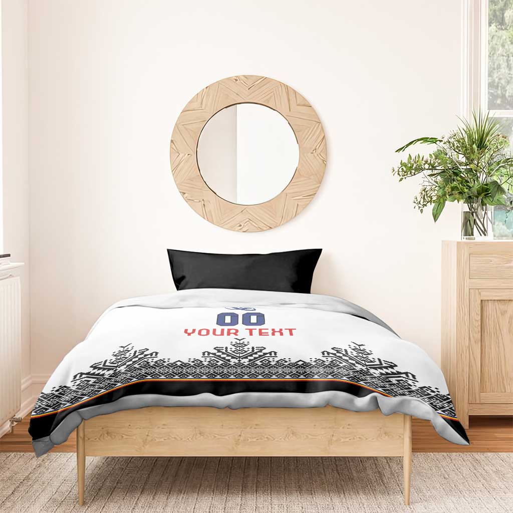 White duvet cover with blue crest, '00' and red 'YOUR TEXT', black Nordic pattern band, black pillows
