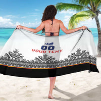 White sarong with black border, custom blue and red text, held open.