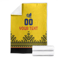 Yellow rugby blanket with blue crest, '00', 'YOUR TEXT', folded with black hem and trim.
